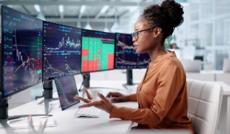 An analyst reviewing market data across several screens